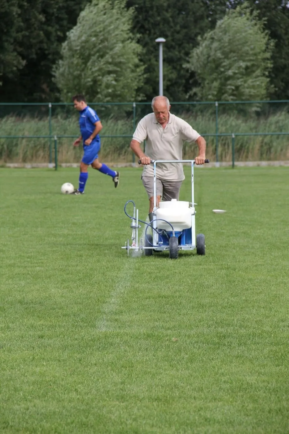 Een vrijwilliger trekt de lijnen op het veld